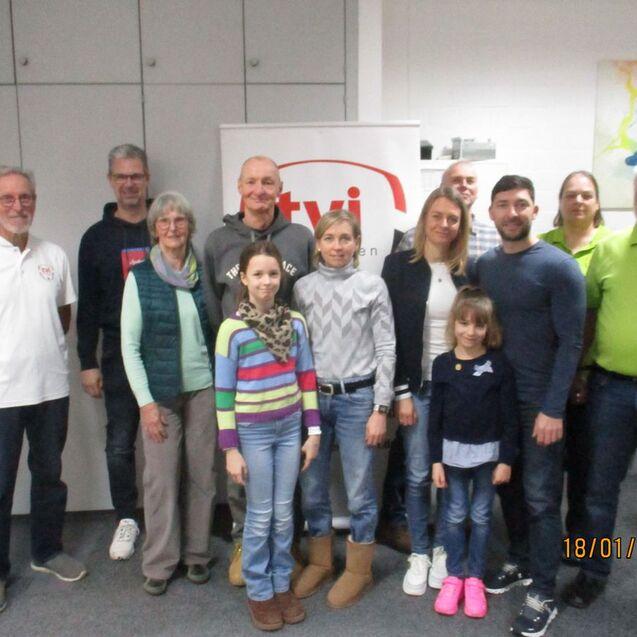 Gruppenfoto von 13 Personen, die vor einem Banner mit dem Logo von tvi stehen, in einem Schulungsraum.