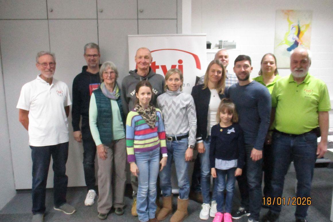 Gruppenfoto von 13 Personen, die vor einem Banner mit dem Logo von tvi stehen, in einem Schulungsraum.