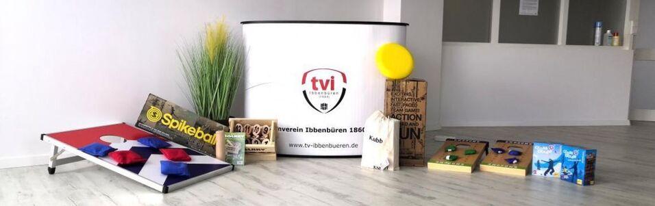 Aufstellung von Spielgeräten und Informationsmaterialien in einem Raum, darunter Spikeball, Spielbretter und Dekoration.